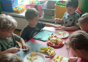 Dzieci robią sałatkę owocową